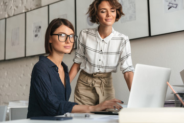 Side view of two smiling women are discussing something