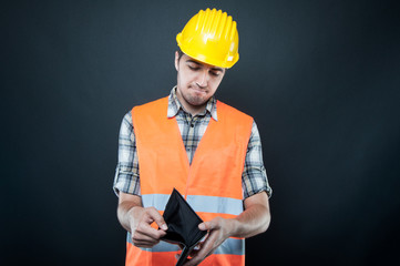 Constructor wearing equipment looking at empty wallet