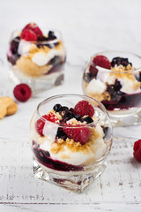 Homemade dessert in glass jars. Cheesecake, trifle, mouse on white wooden background. Copy space