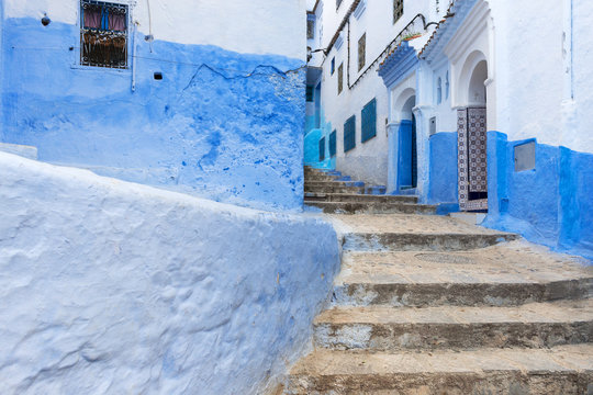 Detail of a narrow street in the mountain town of Chefchaouen with blue buildings, in Morocco; Concept for travel in Morocco
