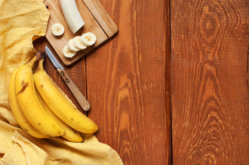 Wooden background with ripe yellow bananas