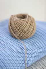 Knitted things. Sweaters are lying on a wooden table. Candles. Autumn. Cozy.