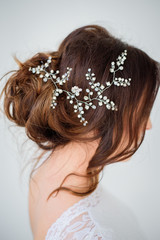 Silver flower wreath put in dark hair of a bride