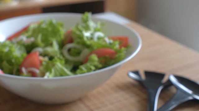 Vegetarian lettuce, onion, tomato and sweet peper salad in a white bowl. Clouse up.