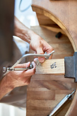 Closeup of jeweler making flower ring in workshop, forming and polishing it on work station with different tools