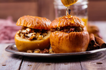 Baked apples stuffed with honey, raisin and nuts. Autumn dessert. Copy space