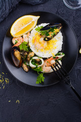 Seafood saute with rice on black stone table