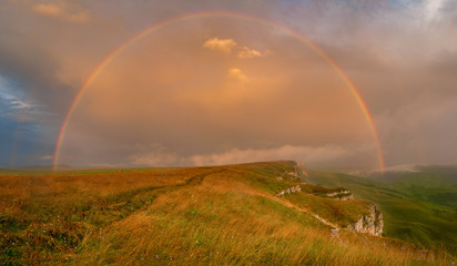 Fototapeta na wymiar rainbow on a high plateau in the evening after the rain