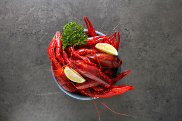 Delicious boiled crayfish close-up with lemon and parsley. Dark 
