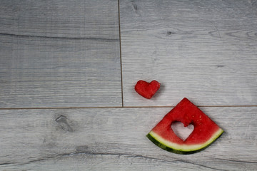 a piece of watermelon with cuted heart on it