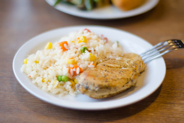 Rice with chicken steak on a plate