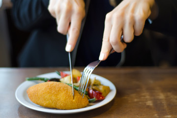 Vegetable stew and chicken cutlet female hands