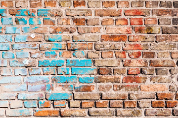 The texture of the brick wall, in some places chaotically painted with old paint of blue and white. You can use it as a background for your design.