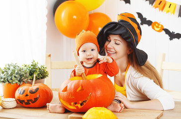 mother and baby cut  pumpkin for Halloween in kitchen