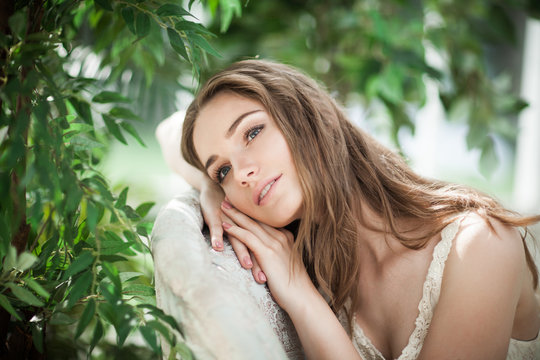 Portrait of Beautiful Woman Fashion Model Relaxing in Green Leaves