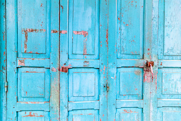 Old house with vintage wooden blue cyan door and gray cement wall. Vintage blue cyan doors concept use for background.