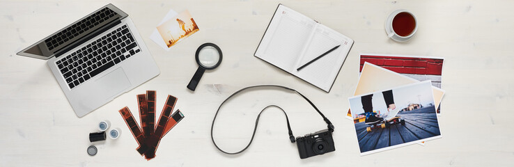 Aerial view of phtotgrapher working desk with equipment: camera, film, negtives, prints, computer,...