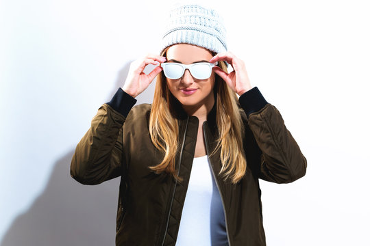 Hipster girl wearing sunglasses and hat on a white background