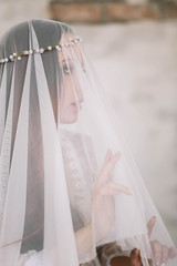 Beautiful brunette bride under a veil, hair ornament, profile, close-up