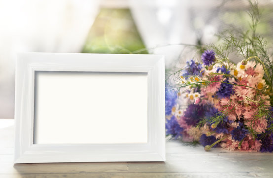 Empty frame mockup and flowers