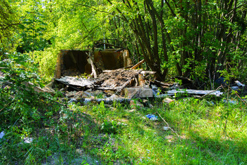Destroyed houses in which people lived in a dead radioactive zone. Consequences of the Chernobyl nuclear disaster and vandalism, August 2017.