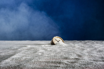 An old alarm clock on white sand and blue background