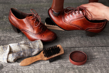 Shoemaker applying shoe shiner on shoe
