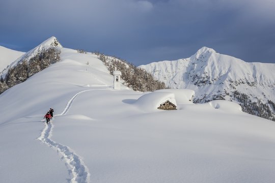 Italy, Italian Alps, Lombardy, The huts and the bell tower of Alpe Cima sorrounded by metres of snow
