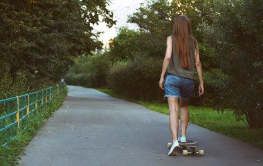 Beautiful young girl riding longboard