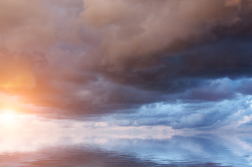 Dramatic clouds at dawn over the calm sea, before the storm.