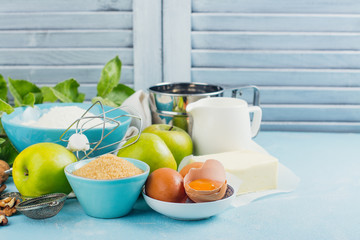 Apple pie ingredients on kitchen table. Space for text