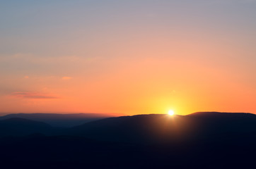 Early dawn in the mountains. The sun just came from behind the top of the mountain.