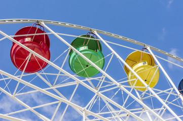 colorful ferris wheel against blue sky with clouds