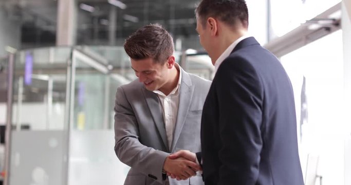Businessmen shaking hands in a corporate office