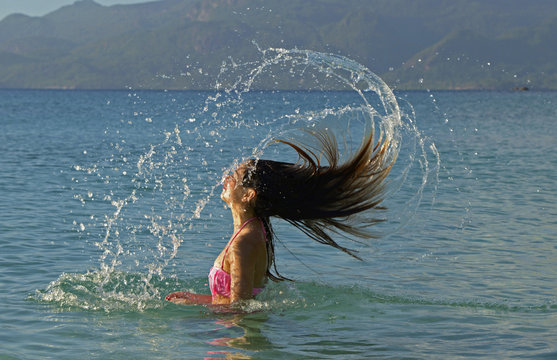 Adolescente secouant ses cheveux dans une gerbe d'eau