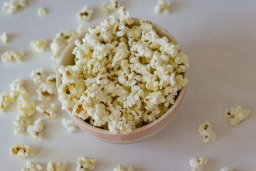Close-up of  bowl with delicious popcorn on a white background. Concept food by nature.