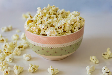 Close-up of  bowl with delicious popcorn on a white background. Concept food by nature.