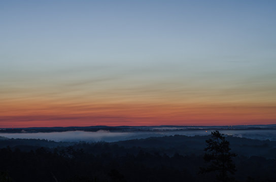 Distant lights and fog near the horizon just before sunrise near Heflin, Alabama, USA
