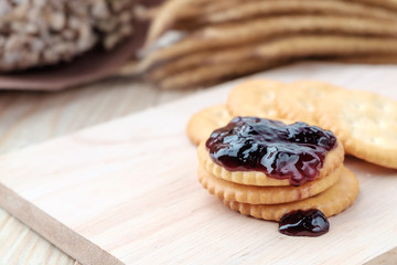 Cracker with jam on woodden background