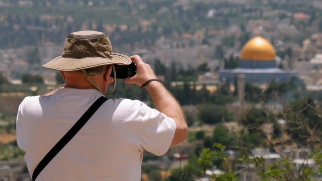 Tourist takes a photo of Jerusalem Old City view. Mount Scopus is a famous Holy Land place and it has a fantastic view to the Old Jerusalem. Jerusalem is a beautiful and popular touristic city.