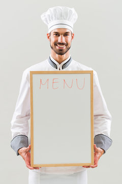 Chef is holding whiteboard on gray background.