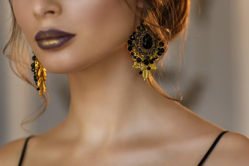 Black jewelry on a female neck, focus on the earring.