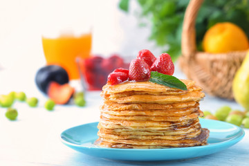 Delicious pancakes with honey and strawberry on table