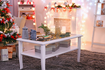 Table with beautiful Christmas decorations and cookies in living room