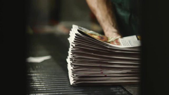 man working on newspaper production line in newspaper factory, printing house