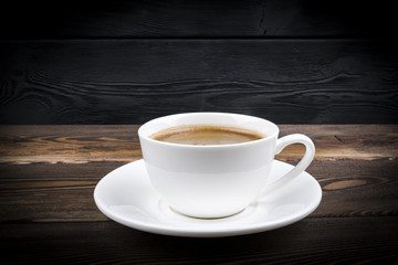 Obraz premium view of a freshly brewed mug of espresso coffee on rustic wooden background with woodgrain texture. Coffee break style, concept