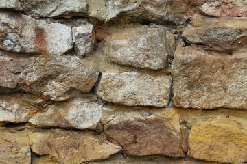 Fototapeta premium Stone brick Wall in the middle of clay, layered stack decoration, sunlight outdoor retro style, backgrounds, wallpaper