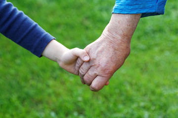 hand of a boy in the hand of a grandmother close-up