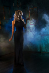 the girl with a cigarette in a  theatrical fog. blurred retrostyle photo.