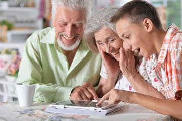 grandparents with grandson using laptop